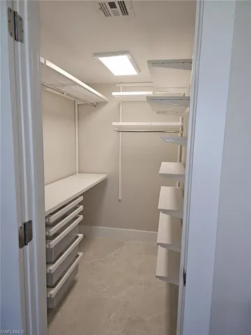 a view of walk in closet with empty racks