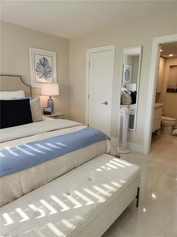 a bedroom with a large bed and painting on the wall