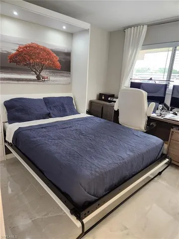 a bed sitting in a bedroom next to a window