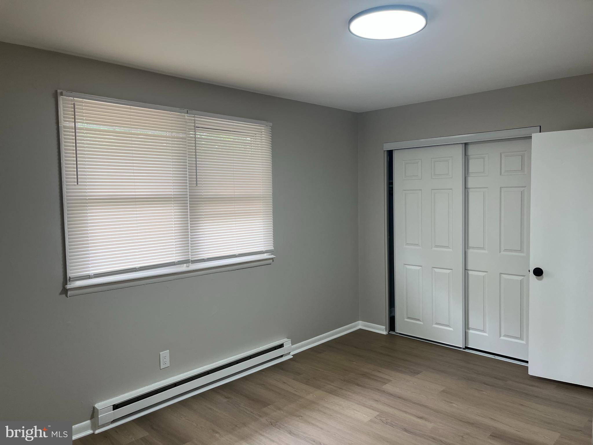 319 Columbia Avenue, Unit 227 Stratford, NJ 08084 - Photo 2 of 13 an empty room with wooden floor and windows
