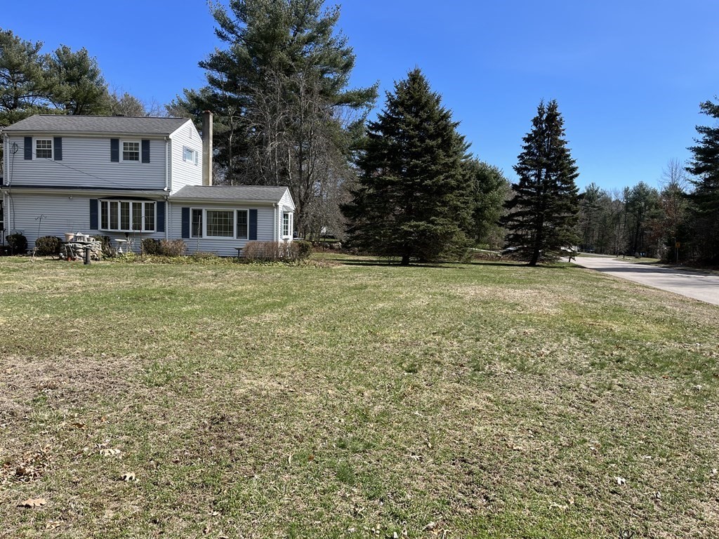 2550 Bay Road Stoughton, MA 02072 - Photo 3 of 20 a tall yellow house with a big yard and large trees