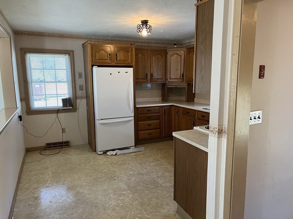 2550 Bay Road Stoughton, MA 02072 - Photo 9 of 20 a kitchen with a refrigerator a stove top oven and cabinets
