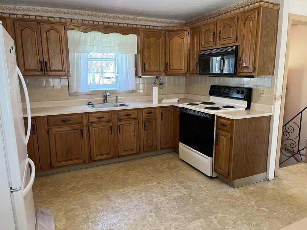 2550 Bay Road Stoughton, MA 02072 - Photo 10 of 20 a kitchen with a stove sink and a microwave