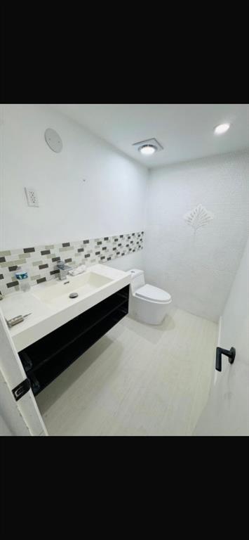 1130 11th Street, Unit 6J Miami Beach, FL 33139 - Photo 5 of 18 a bathroom with a sink a toilet and a mirror