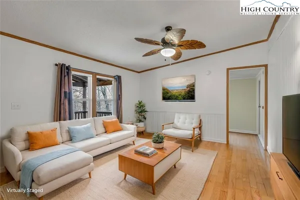 a view of empty room with wooden floor and fan