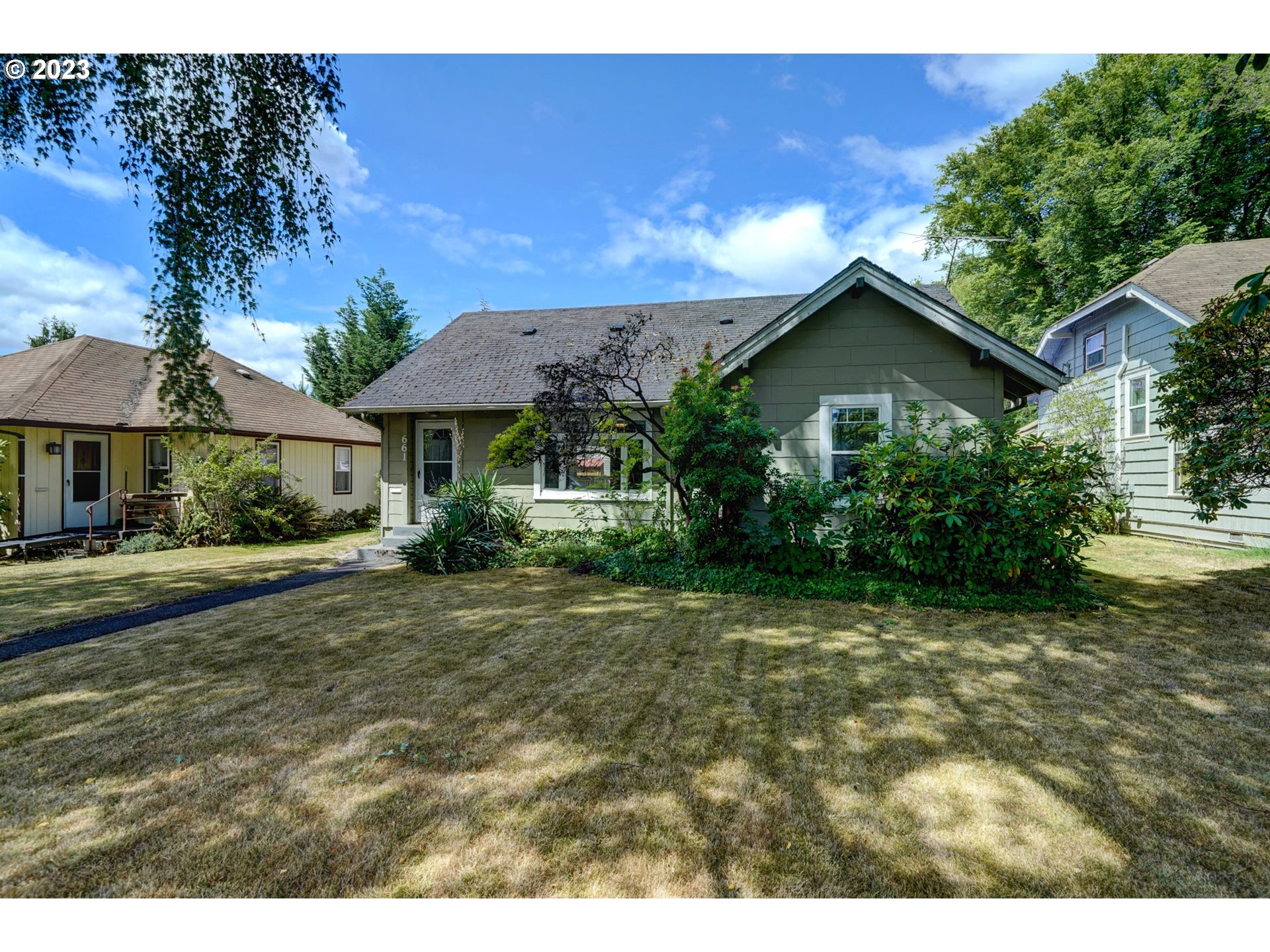 a view of a house with a yard and potted plants