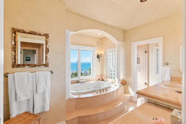 a white bath tub sitting in a bathroom next to a window