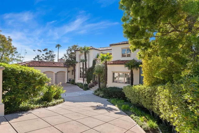 a front view of a house with a yard and potted plants
