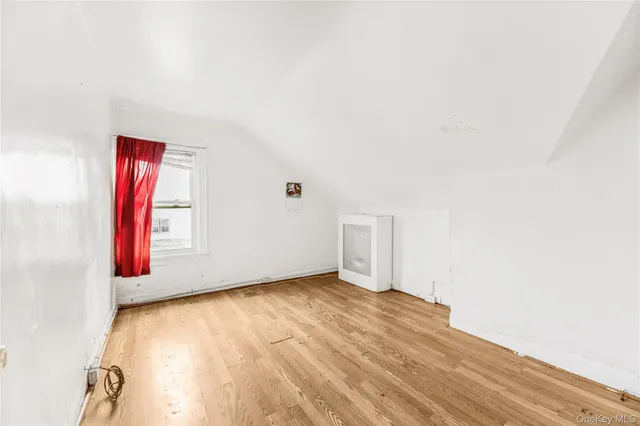 a view of a room with wooden floor and a bathroom
