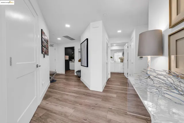 a view of a hallway with wooden floor windows and a living room