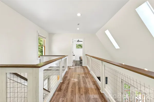 a view of a hallway with wooden floor and staircase