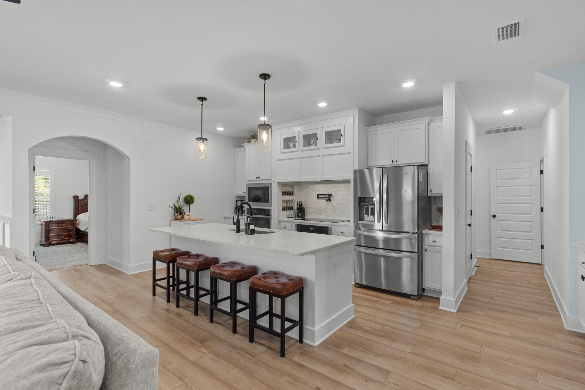 136 Hibernate Way Freeport, FL 32439 - Photo 8 of 55 a kitchen with stainless steel appliances kitchen island granite countertop a refrigerator a stove a microwave oven a dining table and chairs with wooden floor