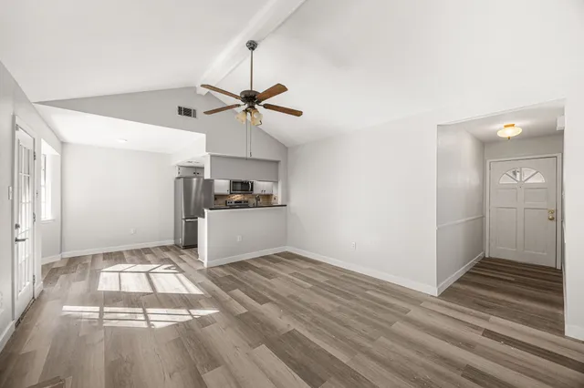 a view of empty room with wooden floor and window