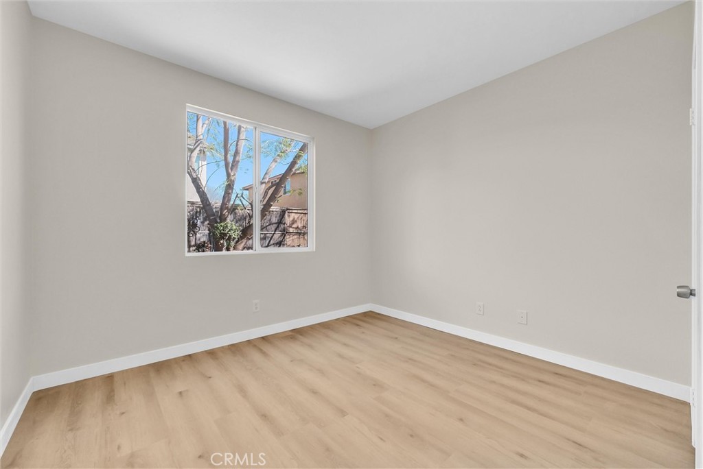 6732 Rico Court Eastvale, CA 92880 - Photo 16 of 30 an empty room with a window and a painting on the wall