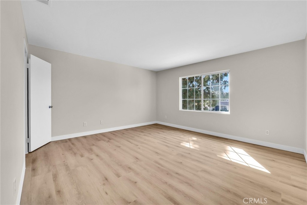6732 Rico Court Eastvale, CA 92880 - Photo 17 of 30 an empty room with wooden floor and windows