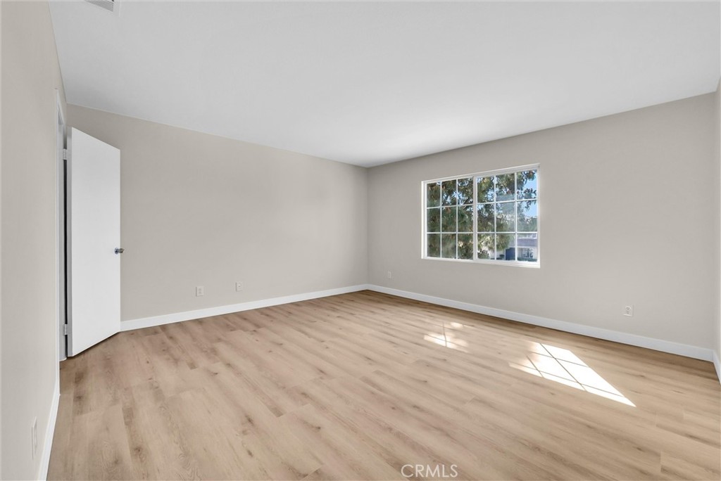 6732 Rico Court Eastvale, CA 92880 - Photo 19 of 30 an empty room with wooden floor and windows
