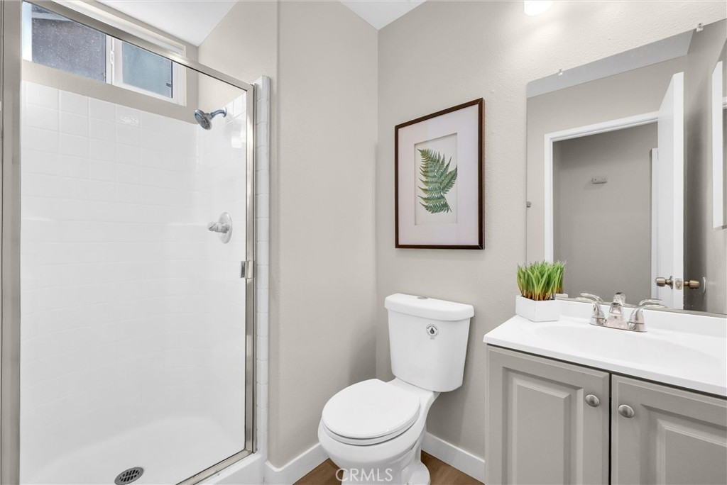 6732 Rico Court Eastvale, CA 92880 - Photo 25 of 30 a bathroom with a toilet a sink and a mirror