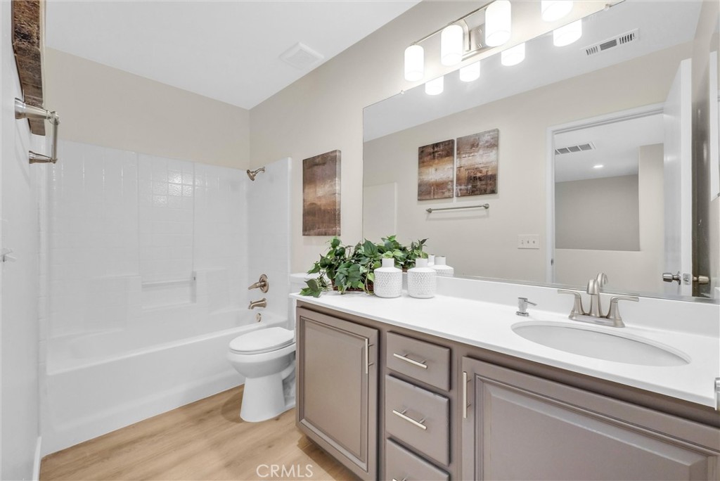 6732 Rico Court Eastvale, CA 92880 - Photo 26 of 30 a bathroom with a sink a toilet and shower