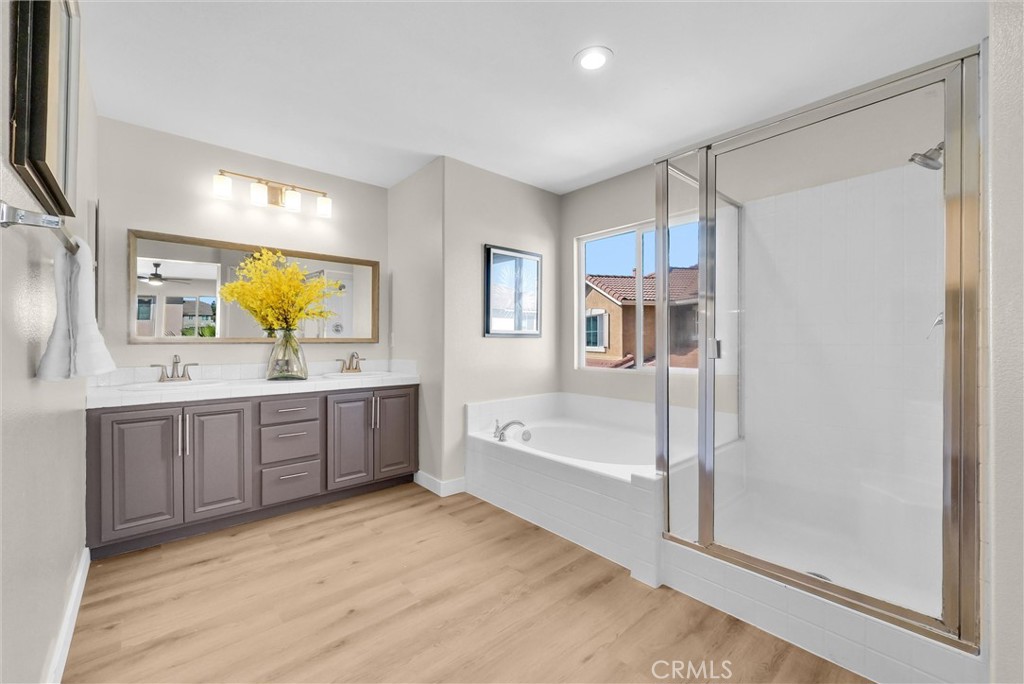 6732 Rico Court Eastvale, CA 92880 - Photo 27 of 30 a spacious bathroom with a tub sink and mirror