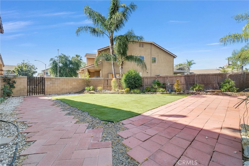 6732 Rico Court Eastvale, CA 92880 - Photo 29 of 30 a white house with a yard plants and large tree