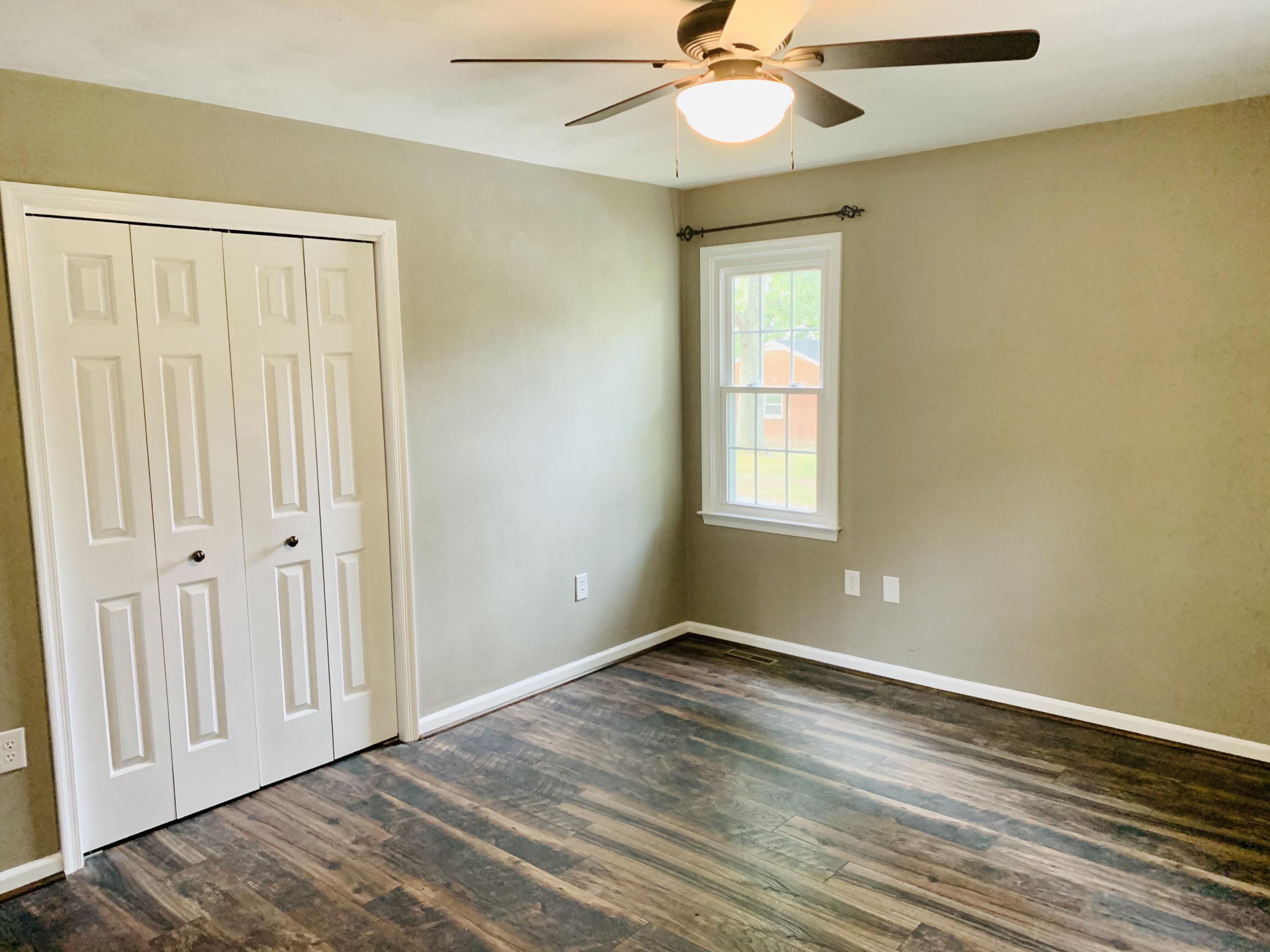1591 Sandy Level Road Goodview, VA 24095 - Photo 12 of 24 a view of an empty room with wooden floor and a window
