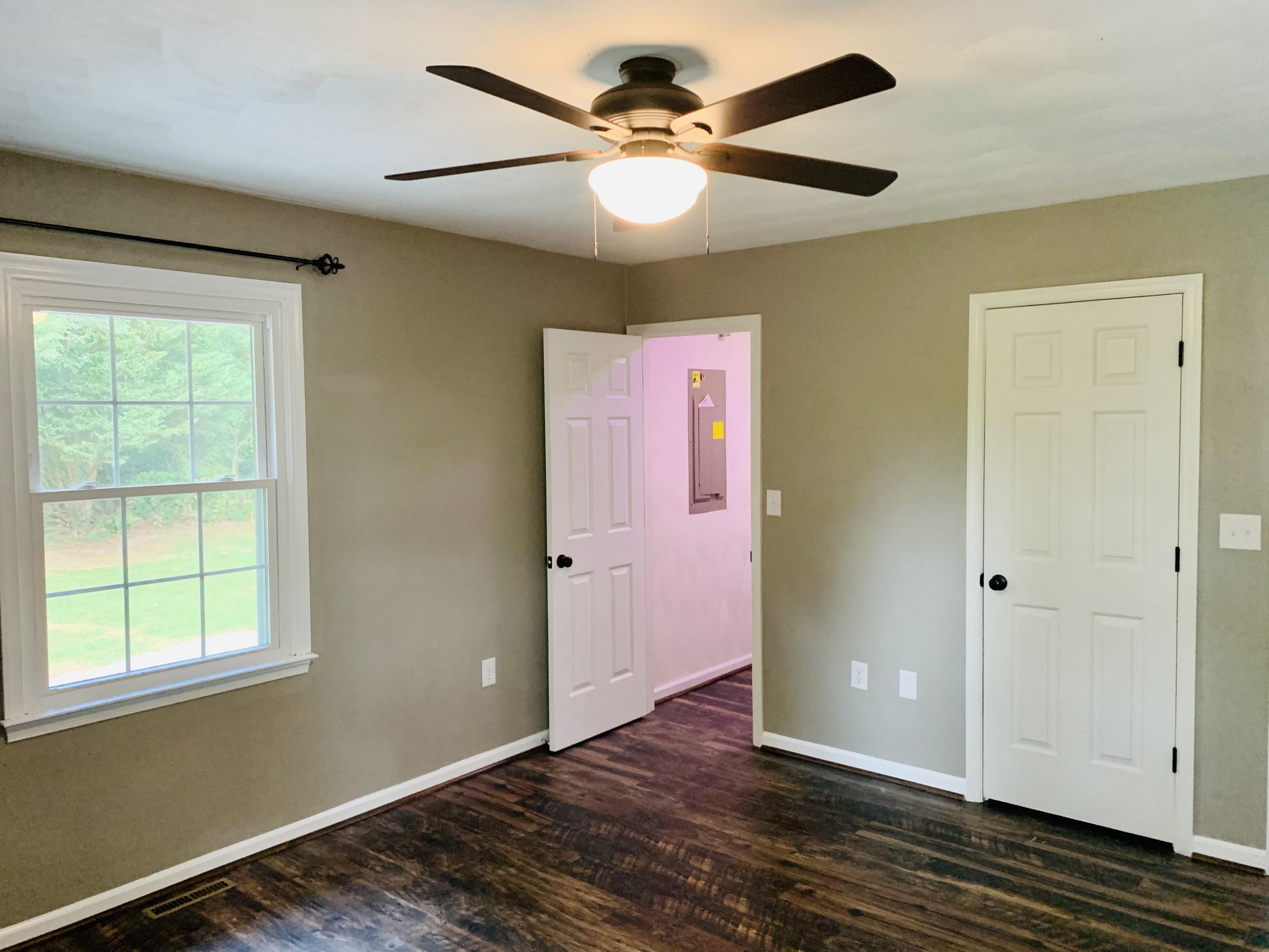 1591 Sandy Level Road Goodview, VA 24095 - Photo 13 of 24 a view of an empty room with window and wooden floor