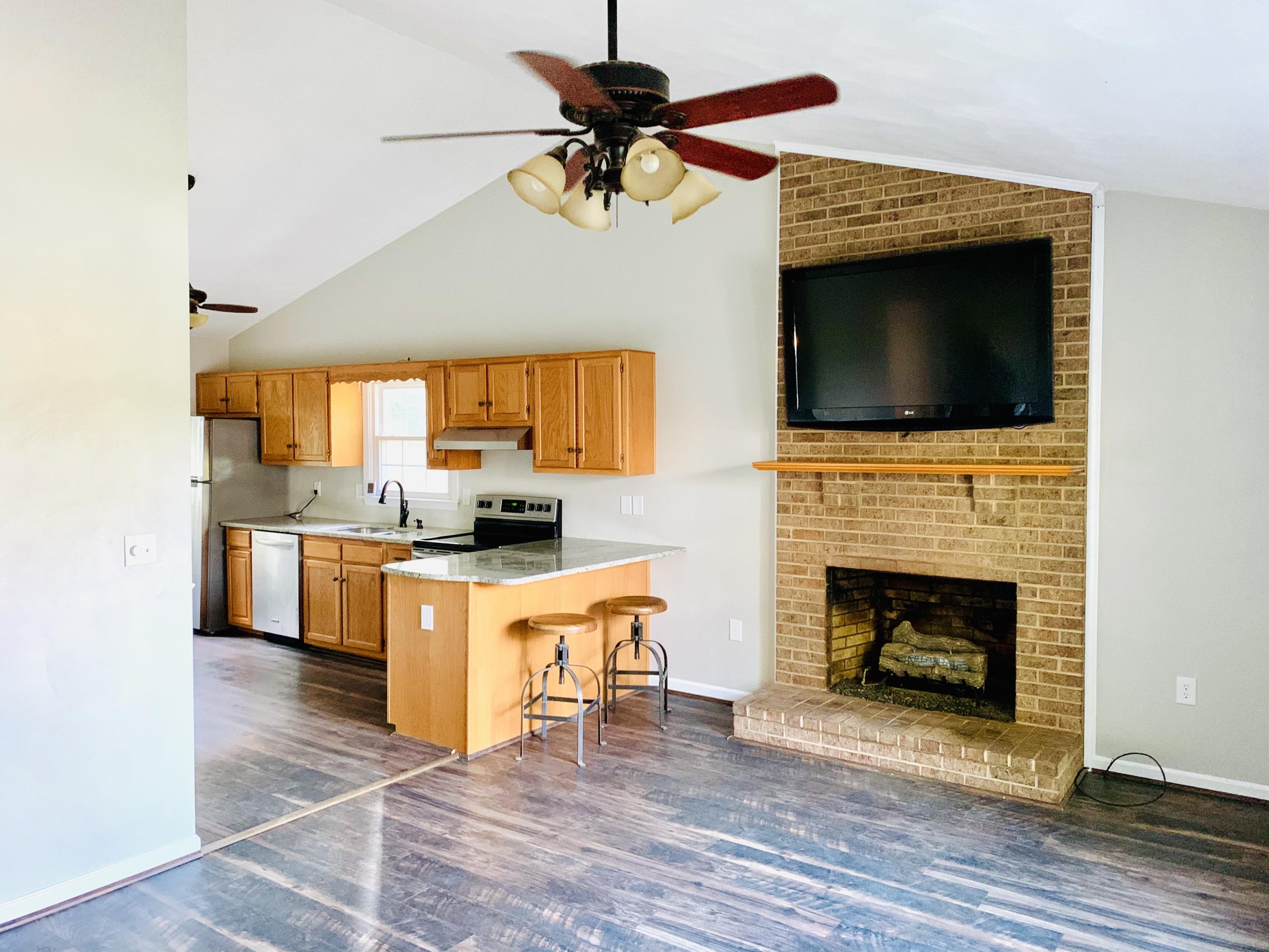 1591 Sandy Level Road Goodview, VA 24095 - Photo 7 of 24 a living room with fireplace a flat screen tv and kitchen view