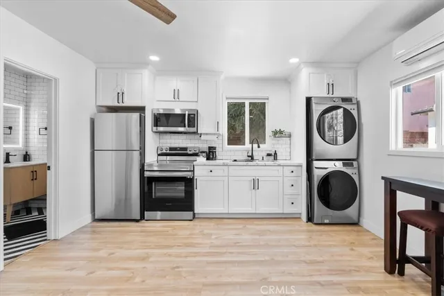 a kitchen with stainless steel appliances granite countertop a refrigerator a stove and white cabinets