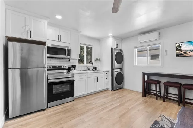 a kitchen with a refrigerator cabinets and wooden floor