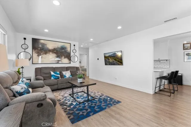 a living room with furniture and a wooden floor