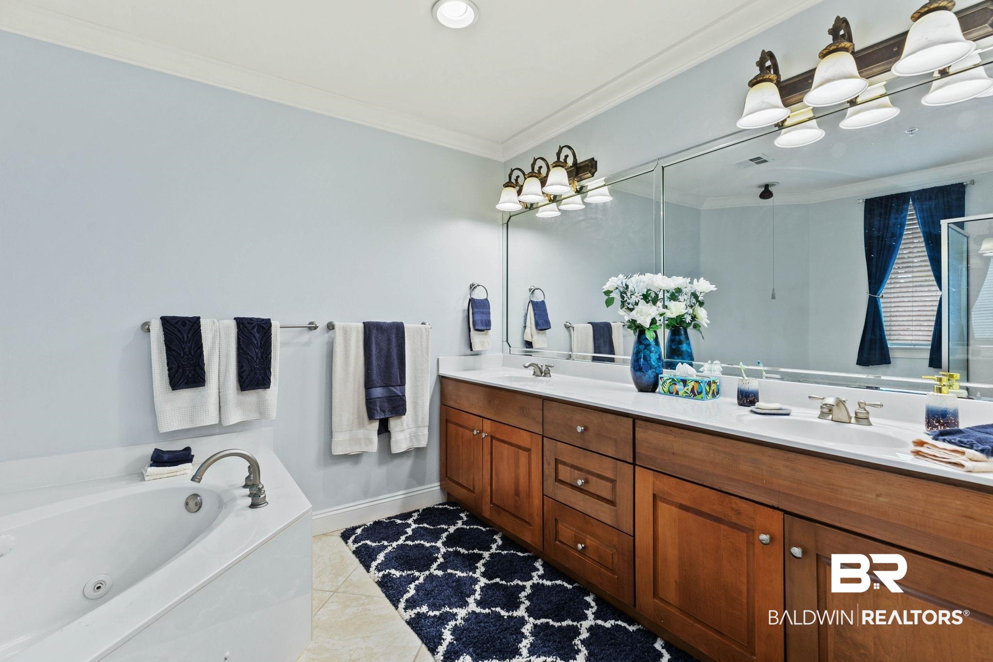 28250 Canal Road, Unit 208 Orange Beach, AL 36561 - Photo 30 of 53 Bathroom featuring double vanity, light tile patterned floors, crown molding, and a jetted tub