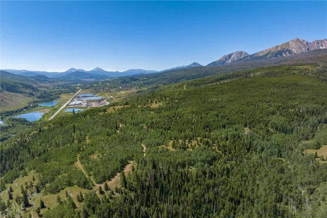 a view of mountain with wooden floor and mountains in the background