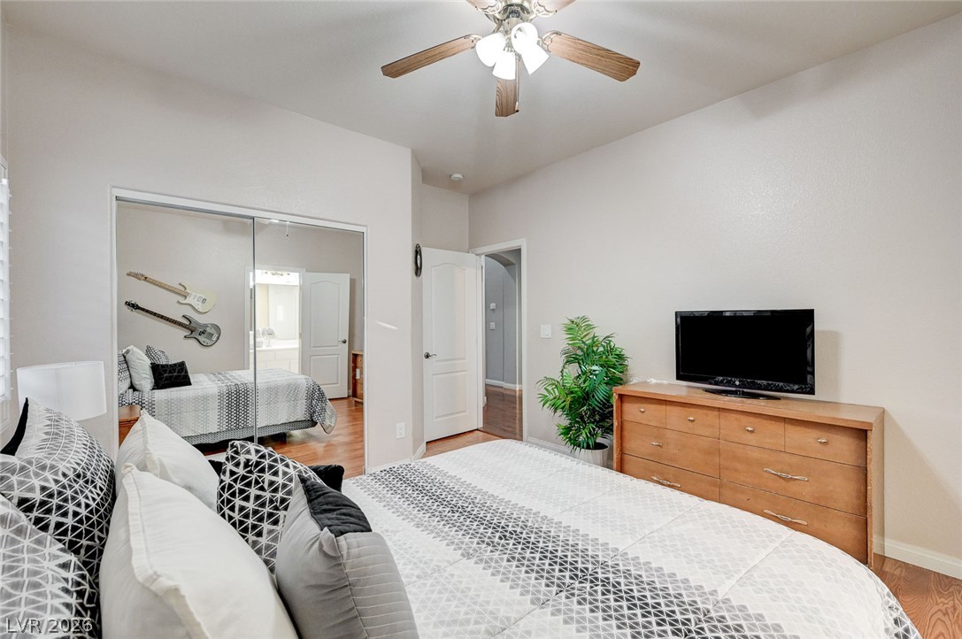 1604 Cattle Ranch Place Henderson, NV 89002 - Photo 52 of 99 Well-lit bedroom with mirrored closet doors and warm hardwood flooring.