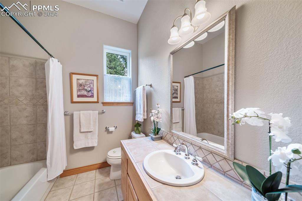 8174 Inca Road Larkspur, CO 80118 - Photo 40 of 50 a bathroom with a sink a large mirror and a shower