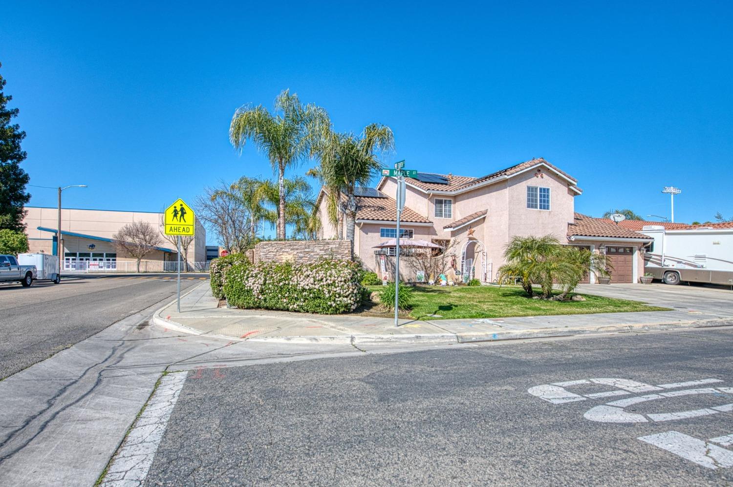 901 Maple Street Parlier, CA 93648 - Photo 65 of 67 a front view of a house with a yard and potted plants