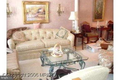 a living room with furniture and a painting on the wall