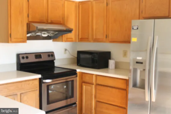 a kitchen with stainless steel appliances a stove a microwave and a refrigerator
