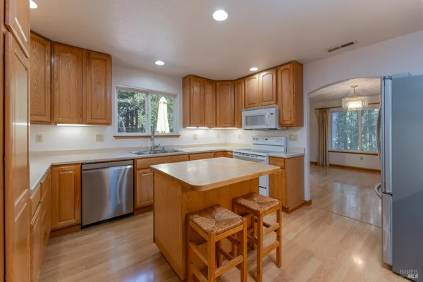a kitchen with granite countertop wooden cabinets a stove a sink and a granite counter top