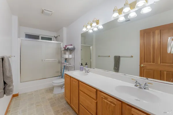 a spacious bathroom with a double vanity sink mirror and toilet