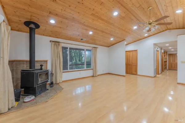 a view of an empty room with a fireplace and a window