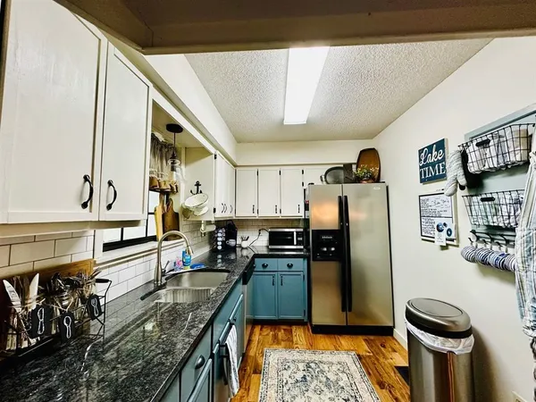 a kitchen with granite countertop cabinets stainless steel appliances and a sink