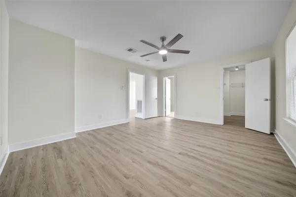 an empty room with wooden floor and windows