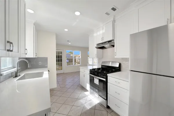 a kitchen with granite countertop a sink stainless steel appliances and cabinets