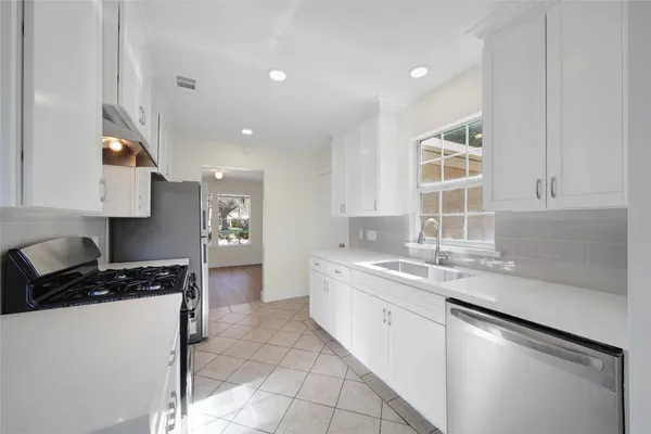 a kitchen with a sink stove and cabinets