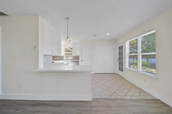 a view of kitchen with granite countertop cabinets and window