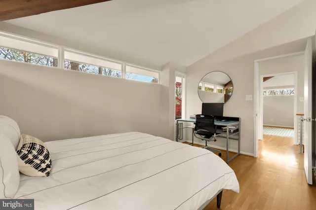 a bedroom with a bed and wooden floor