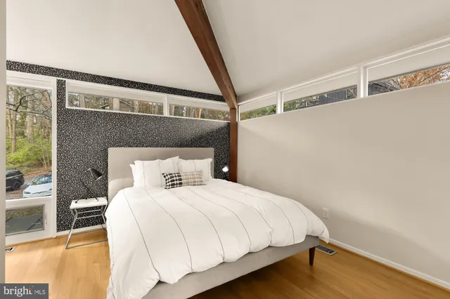 a large bed sitting in a bedroom next to a window