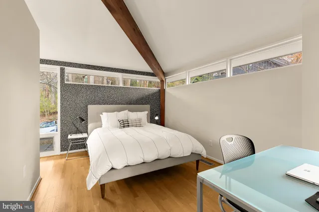 a bedroom with a bed and a large window