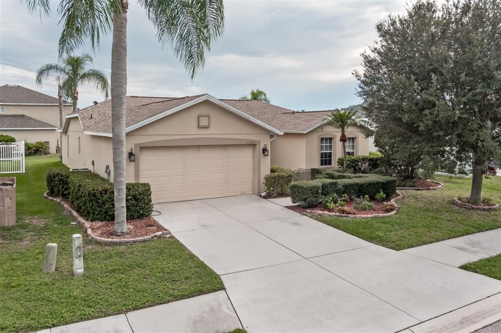 11347 Walden Loop Parrish, FL 34219 - Photo 1 of 29 a front view of a house with garden