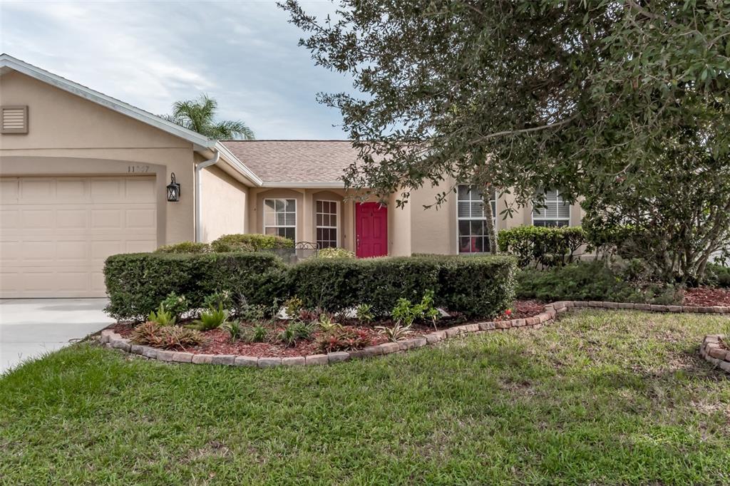 11347 Walden Loop Parrish, FL 34219 - Photo 17 of 29 a front view of white house with a yard and potted plants